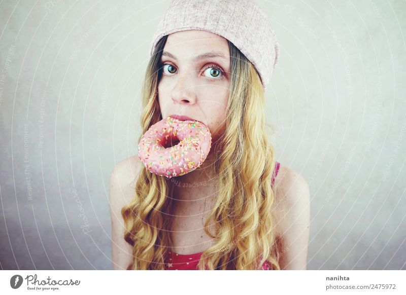 Junge lustige Frau isst einen Donut. Lebensmittel Dessert Süßwaren Krapfen Ernährung Essen Fastfood Lifestyle Stil schön Haare & Frisuren Gesicht Mensch feminin
