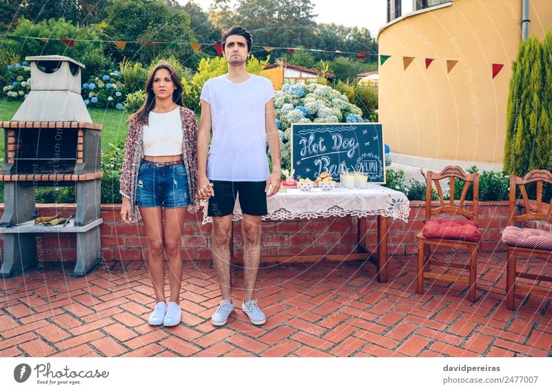 Paar steht in einem Sommergrill im Freien. Brot Brötchen Mittagessen Fastfood Getränk Limonade Lifestyle Freude Erholung Garten Tisch Tafel Mensch Frau