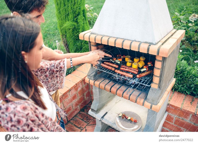 Freunde beim Kochen im Barbecue auf dem Sommerfest Wurstwaren Gemüse Lifestyle Freude Glück Erholung Freizeit & Hobby Garten Frau Erwachsene Mann Freundschaft