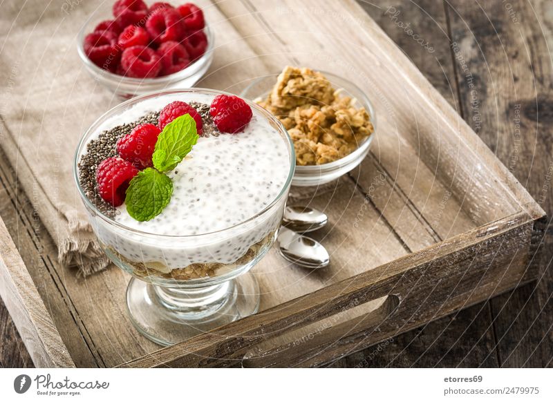 Chia-Joghurt mit Himbeeren im Glas auf Holz Molkerei Frucht Gesunde Ernährung Vegane Ernährung Vegetarische Ernährung Superfood natürlich lecker Samen Dessert
