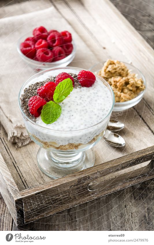 Chia-Joghurt mit Himbeeren im Glas auf Holz Molkerei Frucht Gesundheit Gesunde Ernährung Vegane Ernährung Vegetarische Ernährung Superfood natürlich lecker