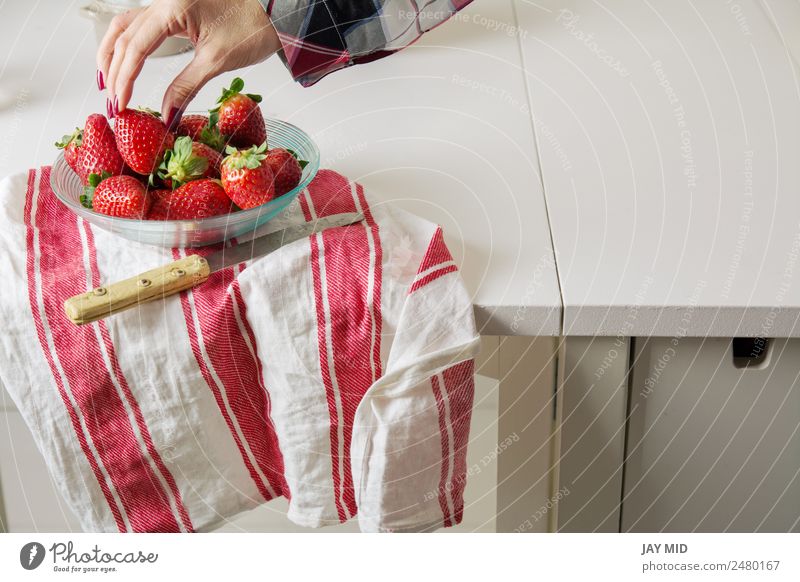 Frau beim Pflücken von Erdbeeren, eine Glasschleife Lebensmittel Fleisch Frucht Ernährung Frühstück Diät Schalen & Schüsseln Lifestyle schön Tisch Mensch