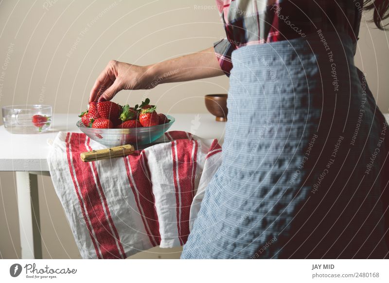 Frau beim Pflücken von Erdbeeren, eine Glasschale Lebensmittel Frucht Ernährung Essen Mensch Erwachsene Hand 1 30-45 Jahre Duft Farbe "Frau; Erdbeere; Schüssel