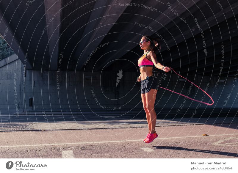 athletische Frau beim Springen mit Springseil Lifestyle Freude schön Körper Gesundheit Gesundheitswesen sportlich Fitness Wellness Leben Wohlgefühl