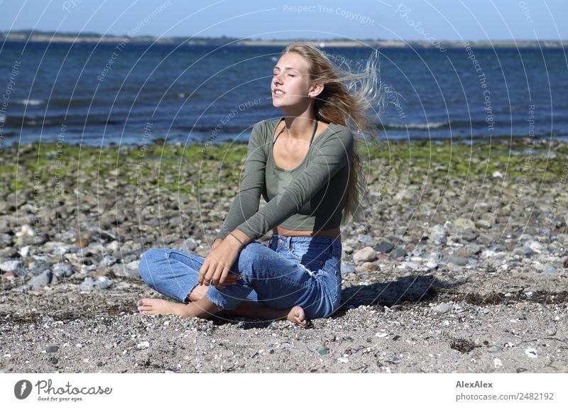Junge Frau am Strand in der Sonne Lifestyle Glück schön Wohlgefühl Sommer Sommerurlaub Sonnenbad Meer Wellen Jugendliche 18-30 Jahre Erwachsene Landschaft