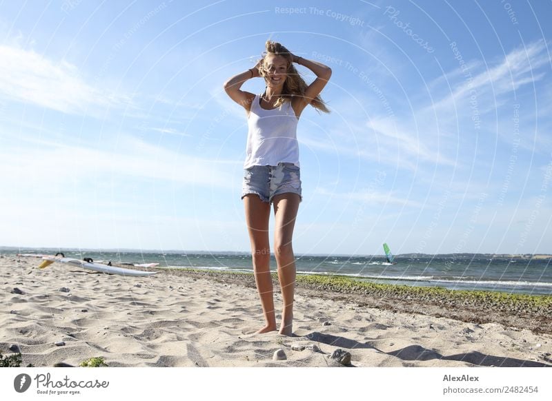 Junge, schlanke Frau am Ostseestrand bei Sommerwind Lifestyle schön Leben Erholung Sommerurlaub Sonne Sonnenbad Strand Meer Wellen Junge Frau Jugendliche