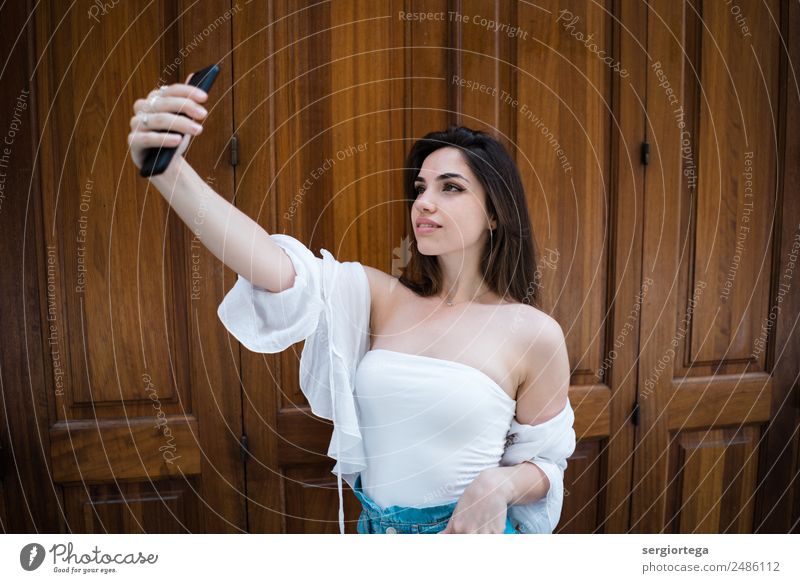 Lächelnde Frau nimmt Selfie an der Holztür. elegant Stil Glück schön ruhig Freizeit & Hobby Sommer PDA Technik & Technologie Erwachsene Bekleidung brünett