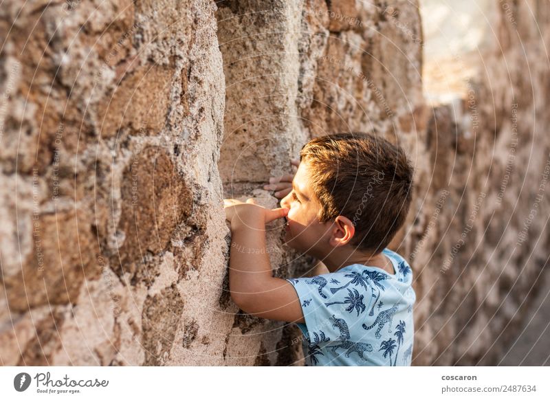 Kleiner Junge schaut durch die Mauer einer Burg. Lifestyle Ferien & Urlaub & Reisen Tourismus Ausflug Abenteuer Sommer Sommerurlaub Kind Baby Kleinkind Kindheit