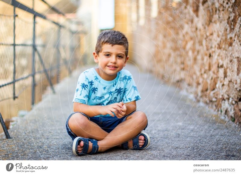 Süßer kleiner Junge, der auf der Mauer eines Schlosses sitzt. Lifestyle schön Ferien & Urlaub & Reisen Tourismus Ausflug Sommerurlaub Kind Baby Kleinkind