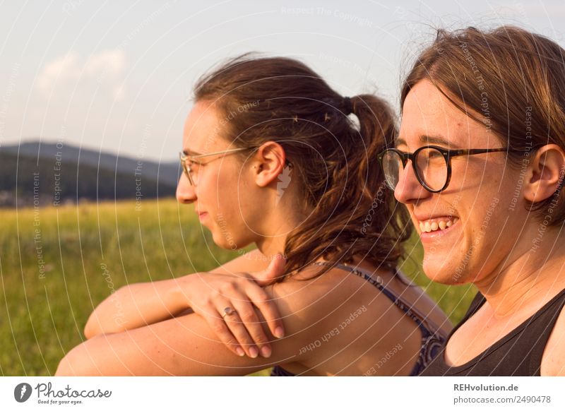 Zwei junge Frauen schauen in die Ferne 18-30 Jahre 2 Natur Landschaft Wiese sitzen natürlich Zufriedenheit Farbfoto Außenaufnahme frei Freizeit & Hobby Freiheit