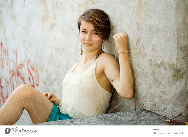 selbst feminin Junge Frau Jugendliche 1 Mensch 18-30 Jahre Erwachsene Mauer Wand brünett kurzhaarig schön sitzen anlehnen Körperhaltung Farbfoto Außenaufnahme