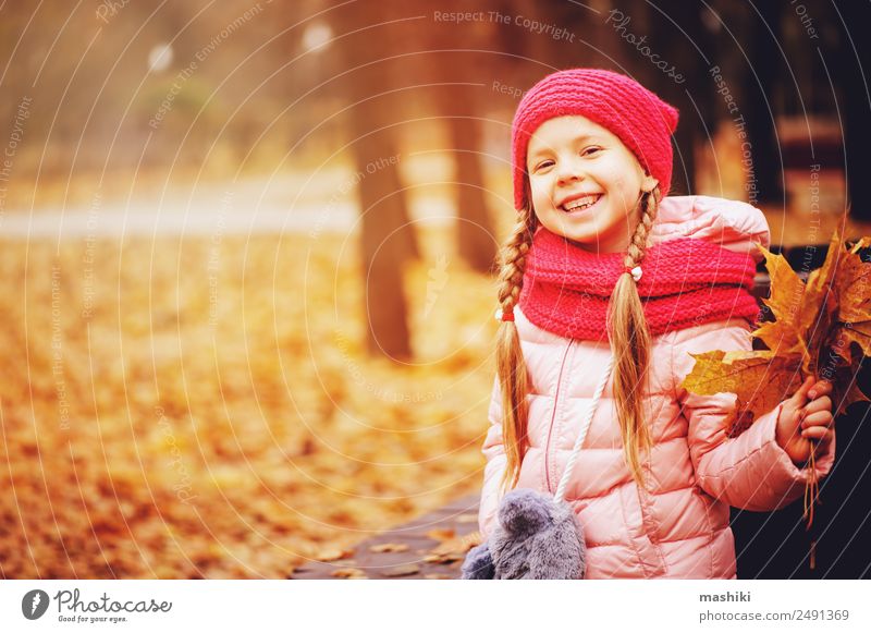 Herbstportrait eines lächelnden Kindmädchens mit Blumenstrauß aus Blättern Stil Freude Glück Freizeit & Hobby stricken Kleinkind Kindheit Natur Wärme Baum Blatt