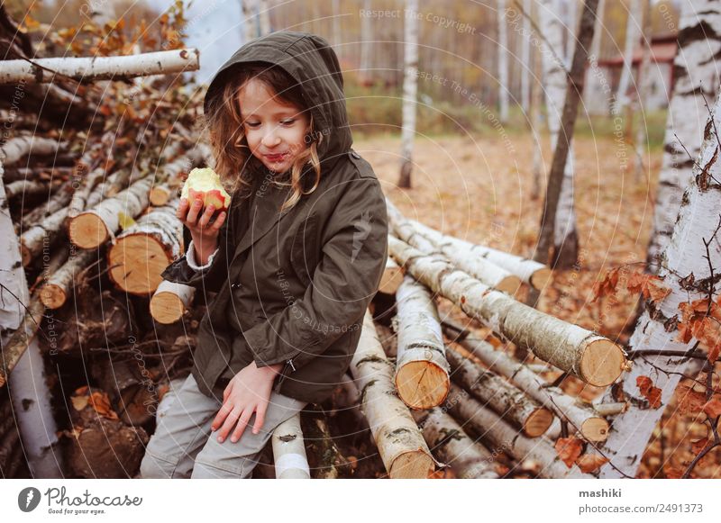 fröhlich lustiges Kind Mädchen isst frischen Apfel im Herbst Frucht Lifestyle Freude Glück Spielen Garten Kindheit Natur Wärme Blatt Wald Schal Lächeln