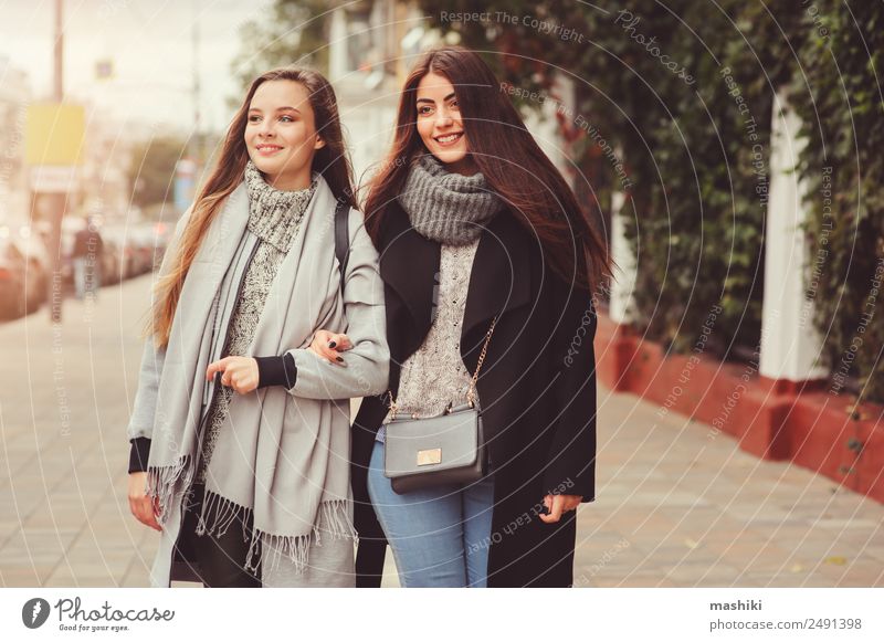 zwei junge, glückliche Freundinnen, die durch die Stadt gehen. Lifestyle sprechen feminin Frau Erwachsene Freundschaft Herbst Wetter Wärme Straße Mode Hemd