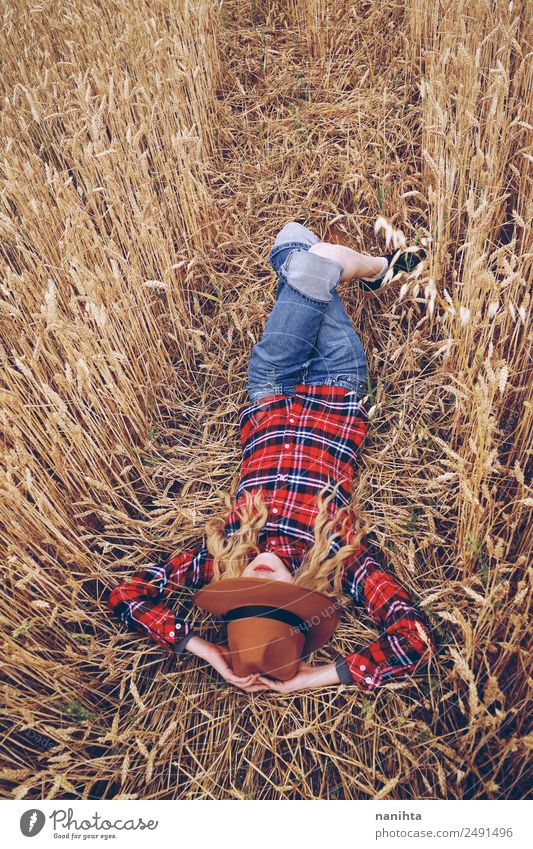 Junge Frau ruht auf einem Weizenfeld. Getreide Bioprodukte Lifestyle Stil Wellness Erholung Freizeit & Hobby Ferien & Urlaub & Reisen Freiheit Sommer