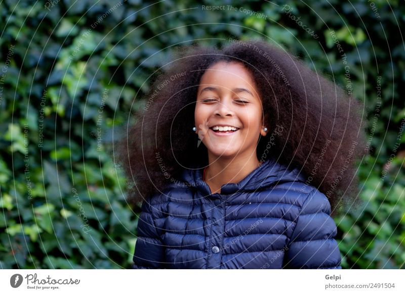 Hübsches Mädchen mit langem Afrohaar. Glück schön Gesicht Winter Garten Kind Mensch Frau Erwachsene Kindheit Park Mantel brünett Afro-Look Lächeln Fröhlichkeit