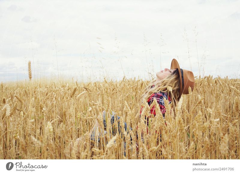 Junge Frau umgeben von Weizenkulturen Getreide Weizenfeld Bioprodukte Lifestyle Stil Freude Wellness harmonisch Wohlgefühl Abenteuer Freiheit Sommer