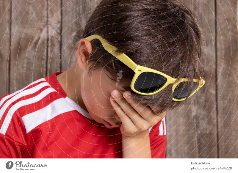 Kind mit Hand vorm Gesicht Junge 1 Mensch 8-13 Jahre Kindheit Sommer Sonnenbrille berühren Traurigkeit Trauer Müdigkeit Unlust Enttäuschung Erschöpfung Sorge
