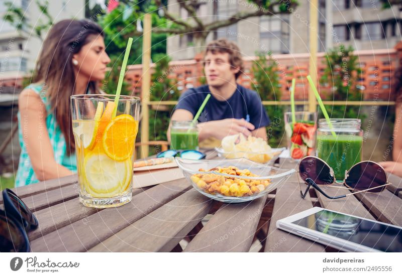 Aufgegossene Fruchtwasser-Cocktails und Gespräche im Hintergrund Gemüse Diät Getränk Saft Freizeit & Hobby Sommer Tisch sprechen Frau Erwachsene Mann