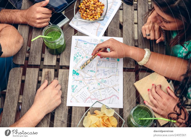 Junge Freunde, die die Karte über einem Tisch betrachten. Saft Lifestyle Ferien & Urlaub & Reisen Tourismus Ausflug Abenteuer Sommer Telefon