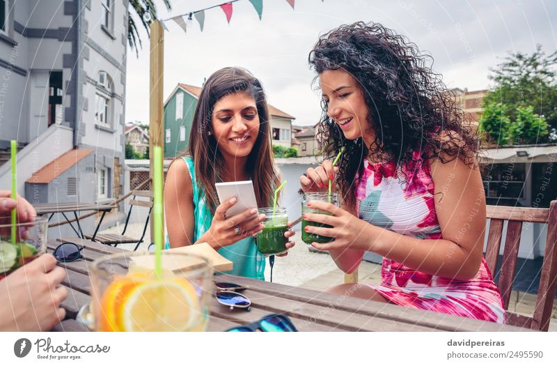 Zwei Frauen, die wie ein Smartphone aussehen und grüne Smoothies trinken. Gemüse Frucht Ernährung Diät Getränk Saft Lifestyle Glück Sommer Telefon PDA