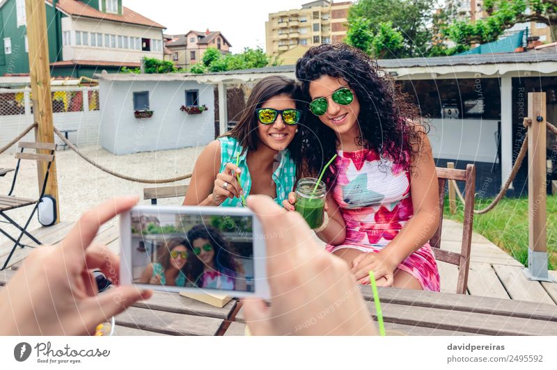 Mann übergibt Fotos mit Smartphone an zwei glückliche junge Frauen Gemüse Frucht Getränk Saft Lifestyle Glück Sommer Telefon PDA Technik & Technologie Mensch