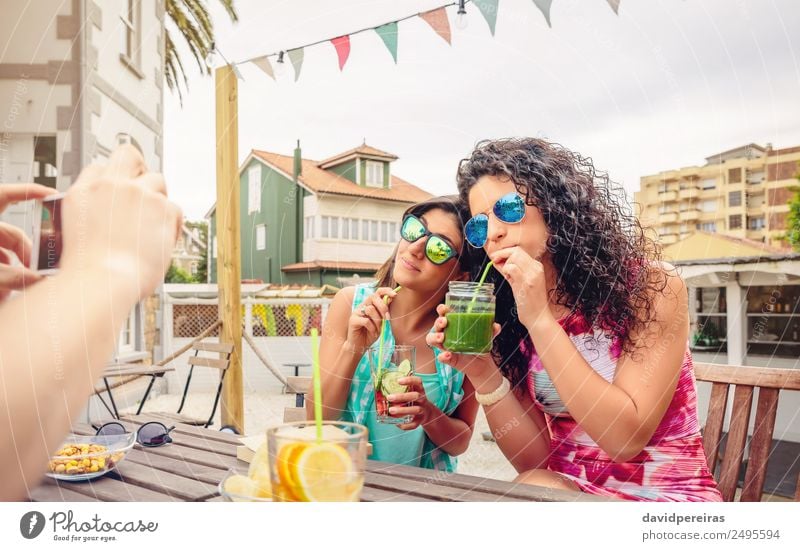Junge Frauenpaar trinkt gesunde Getränke im Freien. Gemüse Frucht trinken Lifestyle Freude Glück schön Freizeit & Hobby Sommer Garten Feste & Feiern Telefon PDA