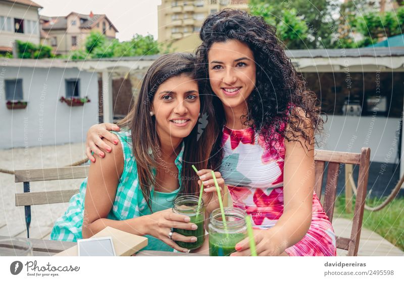Zwei Frauen umarmt mit Smoothies, die auf die Kamera schauen. Gemüse Frucht Getränk Saft Lifestyle Freude Glück Freizeit & Hobby Sommer Mensch Erwachsene