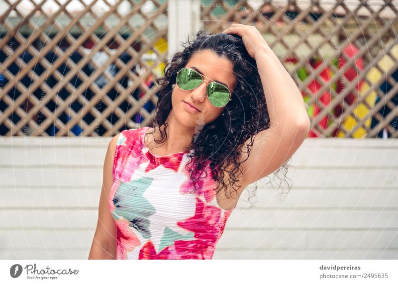 Frau mit Sonnenbrille schaut auf die Kamera über dem Gartenzaun. Lifestyle Freude Glück schön Gesicht Freizeit & Hobby Sommer Spiegel Mensch Erwachsene Kleid