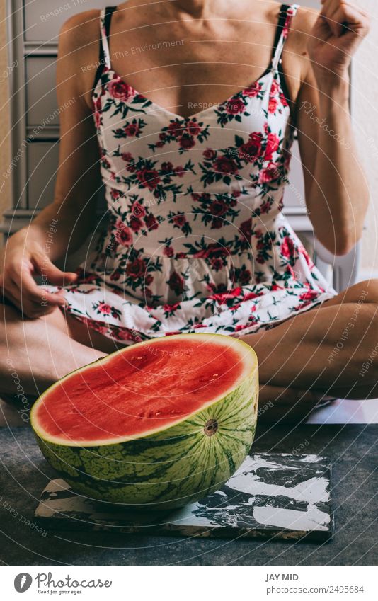 Halbe Wassermelone vor einer schönen Frau mit floralem Kleid Lebensmittel Frucht Ernährung Essen Diät Lifestyle Glück Körper Gesundheit Sommer Mensch Erwachsene
