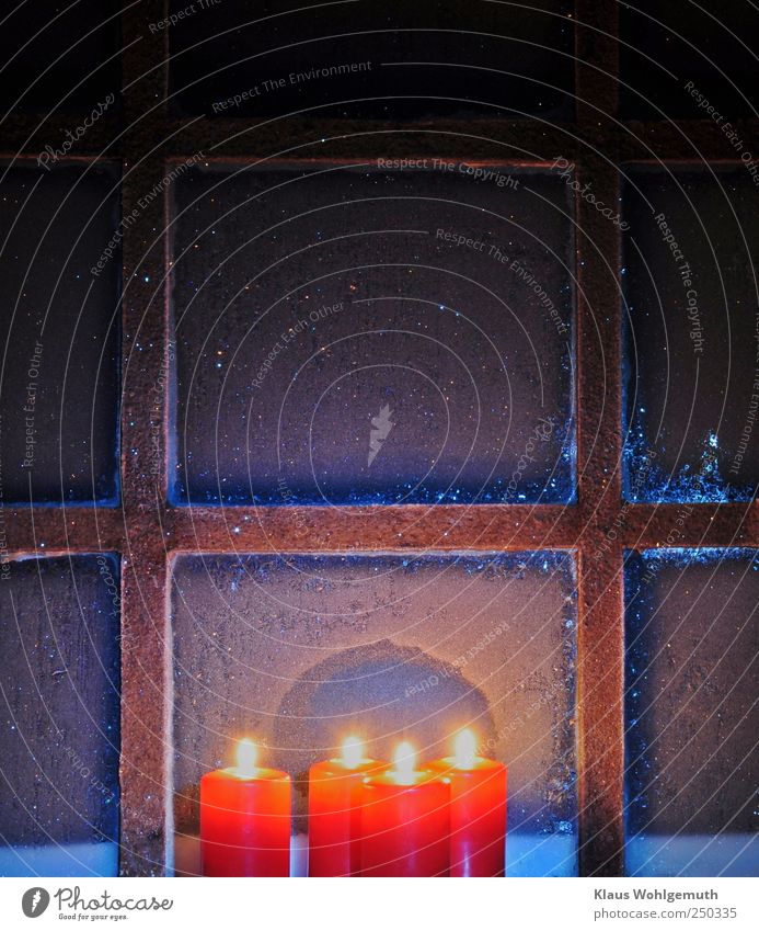 Vier rote Kerzen brennen vor einem vereisten Sprossenfenster mit Eisblumen Winter Schneefall Glas Gold Stahl Kristalle frieren glänzend leuchten blau gelb