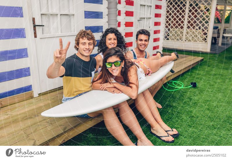 Junge Freunde halten Frau auf dem Surfbrett fest. Lifestyle Freude Glück schön Freizeit & Hobby Ferien & Urlaub & Reisen Sommer Strand Meer Garten Sport