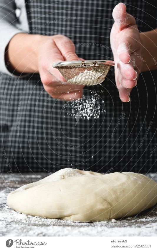 Mehl auf einem Brotteig streuen und kochen. Frau machen Kneten Hand Küche Schürze Hefe gebastelt backen Teigwaren Mensch Vorbereitung rühren Zutaten roh