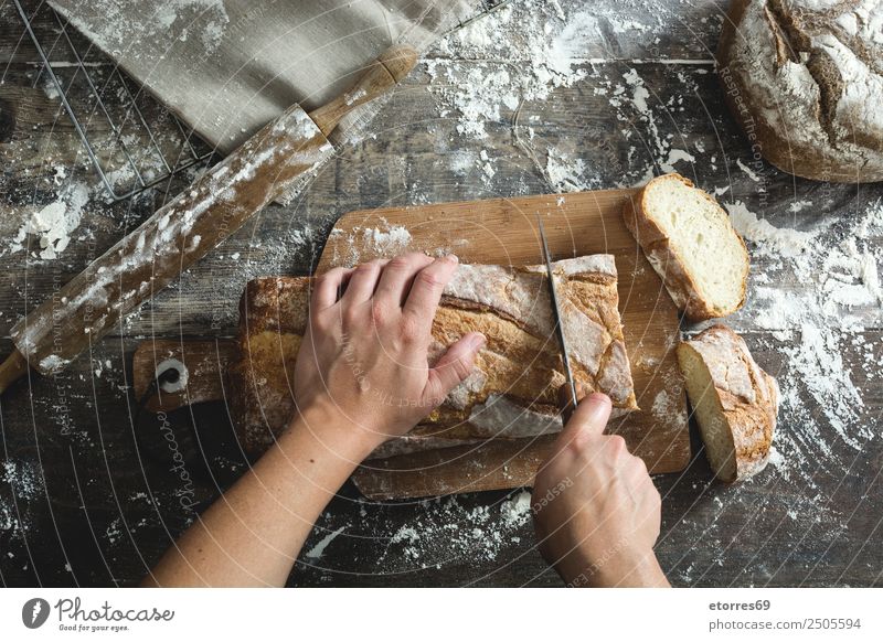 Frau beim Brotschneiden Lebensmittel Tisch Küche Mensch feminin Junge Frau Jugendliche Erwachsene Arme Hand 30-45 Jahre Holz frisch gut braun Schneidewerkzeug