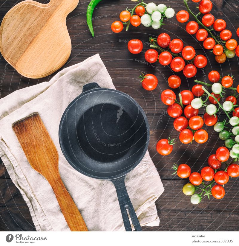 Bratpfanne und reife rote Kirschtomaten Gemüse Vegetarische Ernährung Pfanne Löffel Sommer Küche Holz frisch klein natürlich oben grün schwarz Kirsche Tomate