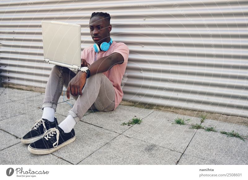 Junger schwarzer Teenager mit seinem Laptop Lifestyle Stil Freizeit & Hobby Student Headset Computer Notebook Kopfhörer Technik & Technologie