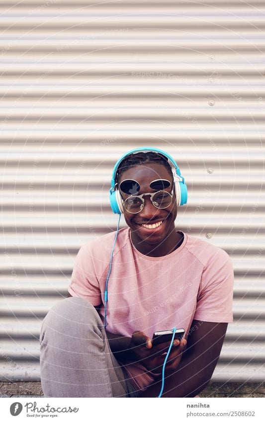 Junger schwarzer Mann, der Musik hört. Lifestyle Stil Freizeit & Hobby Handy Headset Kopfhörer Technik & Technologie Unterhaltungselektronik Mensch maskulin