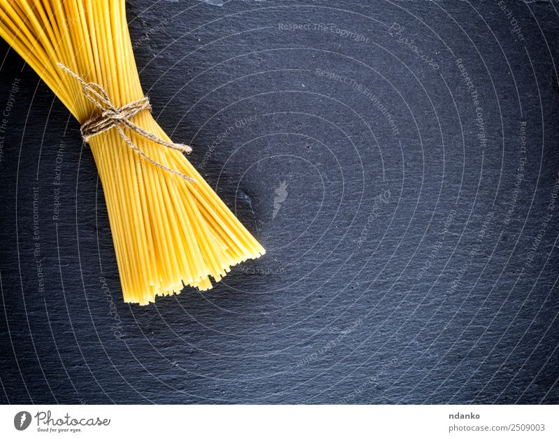 Spaghetti mit einem Seil gebunden Teigwaren Backwaren Mittagessen Linie frisch groß lang oben gelb schwarz Farbe Tradition Spätzle Lebensmittel Hintergrund roh