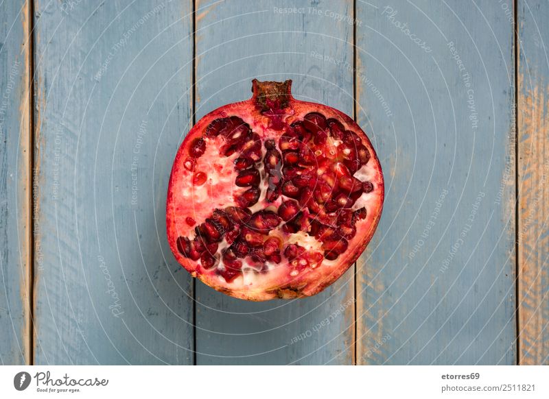 Granatapfel auf blauem Holzgrund Frucht rot Lebensmittel Gesunde Ernährung Foodfotografie Vegetarische Ernährung Diät organisch roh frisch exotisch