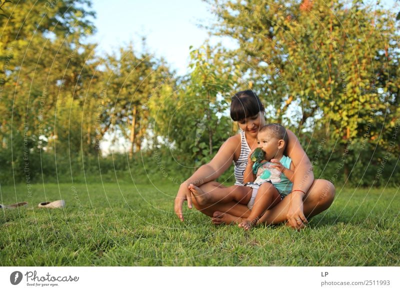 Mutter hält Kind und isst eine Gurke in einem schönen Garten Lifestyle Freizeit & Hobby Spielen Muttertag Mensch Baby Junge Frau Jugendliche Erwachsene Eltern