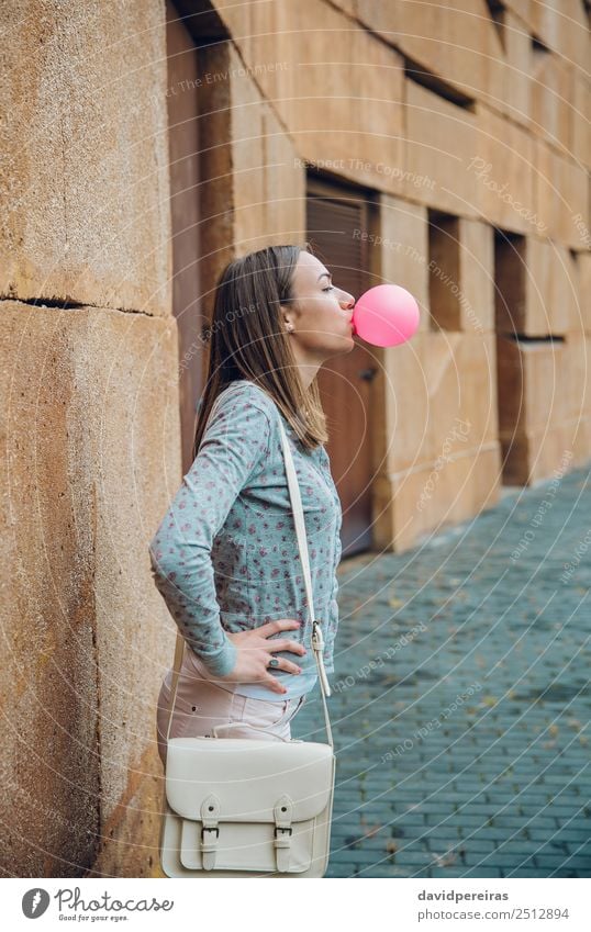 Junges Teenagermädchen, das rosa Kaugummi bläst. Lifestyle Freude Glück schön Gesicht Mensch Frau Erwachsene Jugendliche Mund Lippen Mode brünett Luftballon