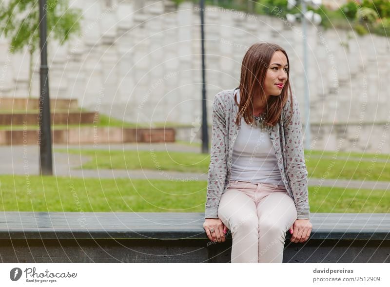 Schöne junge Frau auf der Parkbank sitzend Lifestyle Stil Glück schön Freizeit & Hobby Mensch Erwachsene Natur Herbst Gras Mode Bekleidung Jeanshose Jacke
