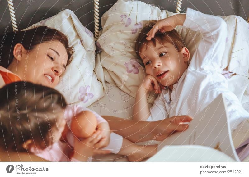 Mutter liest ihren Söhnen im Bett ein Buch vor. Lifestyle Freude Glück schön Erholung Freizeit & Hobby lesen Schlafzimmer Kind Baby Junge Frau Erwachsene Eltern