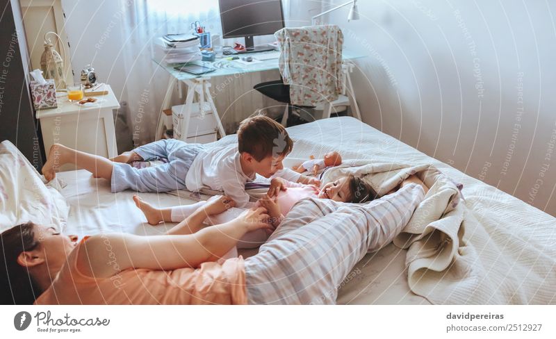 Entspannte Mutter und Söhne spielen über dem Bett. Lifestyle Freude Glück schön Erholung Freizeit & Hobby Spielen Schlafzimmer Kind Baby Junge Frau Erwachsene