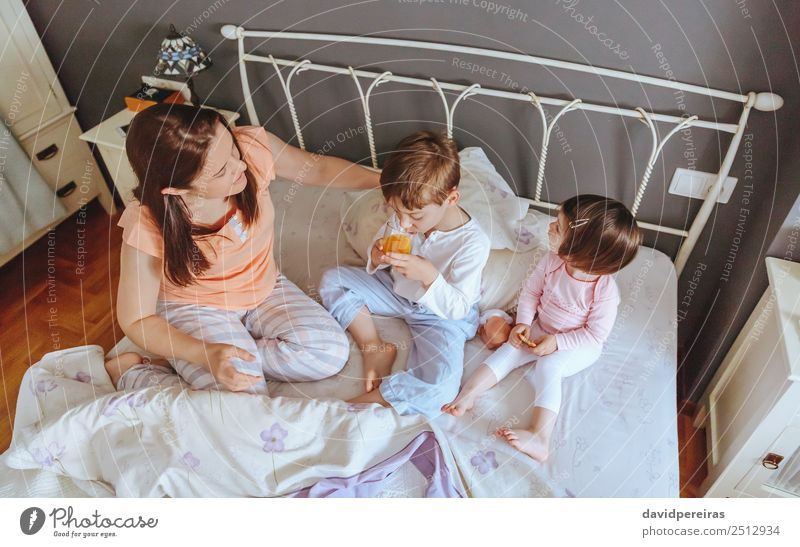 Entspannte Kinder beim Frühstück über dem Bett Essen Saft Lifestyle Freude Glück schön Erholung Freizeit & Hobby Schlafzimmer Baby Junge Frau Erwachsene Eltern