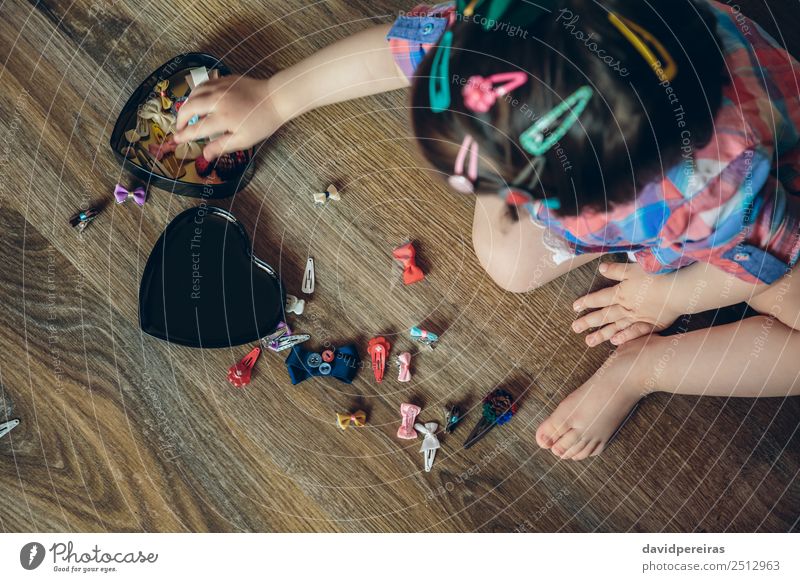 Baby Mädchen spielt mit Haarspangen, die auf dem Boden sitzen. Lifestyle Freude Glück schön Haare & Frisuren Spielen Haus Kind Mensch Frau Erwachsene Hand Mode