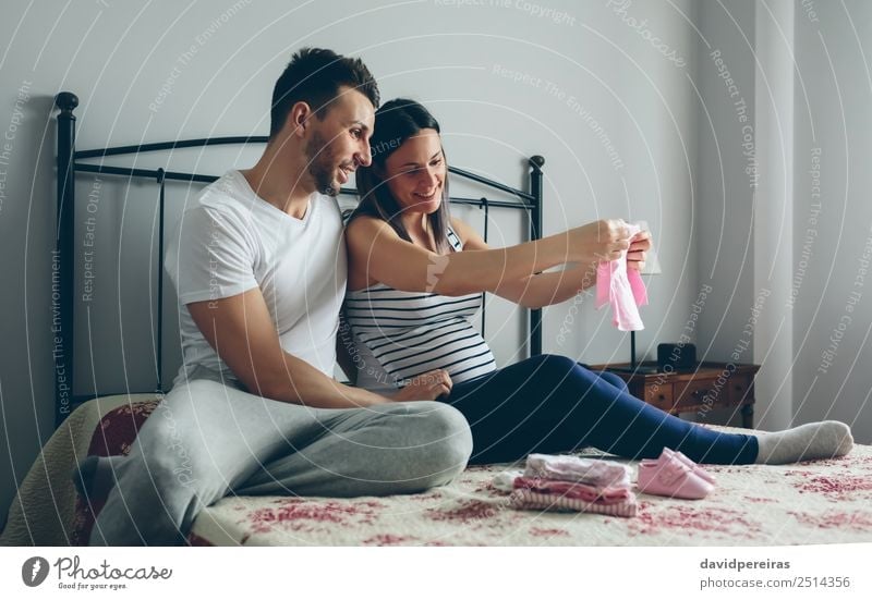 Mann und schwangere Frau suchen Babykleidung Glück schön Schlafzimmer Krankenhaus Mensch Erwachsene Mutter Vater Familie & Verwandtschaft Paar Partner
