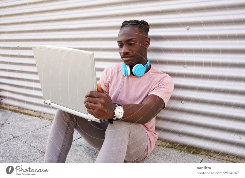 Junger schwarzer Mann mit seinem Laptop Lifestyle Stil Schüler Arbeit & Erwerbstätigkeit Headset Computer Notebook Kopfhörer Technik & Technologie