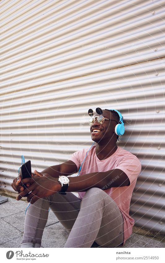 Junger glücklicher Mann, der Musik hört. Lifestyle elegant Stil Freude Freizeit & Hobby Handy Headset Kopfhörer Technik & Technologie Unterhaltungselektronik