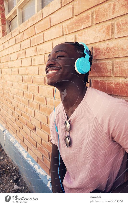 Junger glücklicher schwarzer Mann hört Musik. Lifestyle Stil Freude Wellness Wohlgefühl Zufriedenheit Headset Kopfhörer Technik & Technologie